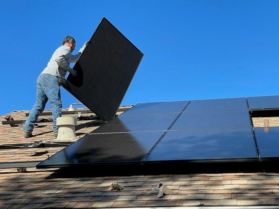 Técnico posicionando uma placa solar sobre o telhado